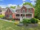 Beautiful two-story brick home with a welcoming front porch, manicured lawn, and colorful landscaping at 3070 Corsair Curv, Cumming, GA 30040