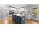 White kitchen with stainless steel appliances, a center island, and access to the backyard at 3070 Corsair Curv, Cumming, GA 30040