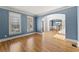 Bright living room with blue walls, large windows, and hardwood floors leading to the stairs at 3070 Corsair Curv, Cumming, GA 30040