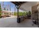 Covered outdoor kitchen and living space overlooks the pool area with bar seating and grill at 3070 Corsair Curv, Cumming, GA 30040