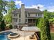 Expansive home rear featuring a pool, hot tub, manicured landscaping, and covered patio, ideal for outdoor living at 3070 Corsair Curv, Cumming, GA 30040