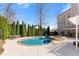 Serene backyard featuring a sparkling swimming pool, hot tub, lush landscaping, and patio seating area at 3070 Corsair Curv, Cumming, GA 30040