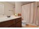 Well-lit bathroom featuring a vanity with a sink and a shower with peach colored curtain at 7347 Moss Stone Dr, Conyers, GA 30094
