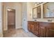 Bathroom with double sink vanity, tiled floors, and doorway to a closet at 7347 Moss Stone Dr, Conyers, GA 30094