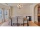 Formal dining room with wainscoting, chandelier, seating for six, and hardwood flooring at 7347 Moss Stone Dr, Conyers, GA 30094