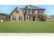 Two-story brick home with a manicured front lawn and symmetrical window and shutter design at 7347 Moss Stone Dr, Conyers, GA 30094