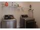 Laundry room featuring front load washer and dryer with shelving, iron, and various cleaning supplies at 7347 Moss Stone Dr, Conyers, GA 30094