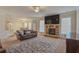 Open-concept living room with stone fireplace, plush seating and eat in kitchen at 7347 Moss Stone Dr, Conyers, GA 30094