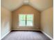 Attic space with neutral paint, carpet flooring and natural light entering through the window at 125 Honey Creek Rd, Conyers, GA 30094