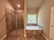 Luxurious bathroom with a glass shower, soaking tub, and a large window at 125 Honey Creek Rd, Conyers, GA 30094