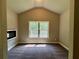 Bedroom featuring a vaulted ceiling, modern fireplace, a window overlooking the yard, and carpet flooring at 125 Honey Creek Rd, Conyers, GA 30094