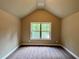 Comfortable bedroom featuring neutral walls, carpet, and a window with a peaceful outdoor view at 125 Honey Creek Rd, Conyers, GA 30094