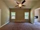 Main bedroom with two windows, a ceiling fan, carpet flooring, and neutral walls, offering a cozy retreat at 125 Honey Creek Rd, Conyers, GA 30094