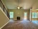 Spacious living room featuring a fireplace, large windows, and a ceiling fan, providing ample natural light at 125 Honey Creek Rd, Conyers, GA 30094