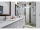 Bathroom featuring dual sinks, quartz countertops, decorative mirrors, modern fixtures, and a glass shower at 2323 Mason Dr # D21, Atlanta, GA 30316