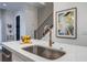 Close-up of kitchen island with quartz countertop, gold faucet, and view of the stairs at 2323 Mason Dr # D21, Atlanta, GA 30316