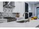 Close-up of kitchen island with white countertops, stainless steel appliances, and stylish backsplash at 2323 Mason Dr # D21, Atlanta, GA 30316