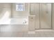 Bright bathroom features a soaking tub and separate glass-enclosed shower, perfect for relaxation at 1832 Glenwood Ln, Snellville, GA 30078