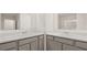 Symmetrical double sink bathroom design with neutral marble counters and gray cabinets at 464 Reflection Dr # 22, Stockbridge, GA 30281