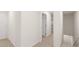 Hallway with white doors and neutral carpet leading to stairway, kitchen and doorway at 464 Reflection Dr # 22, Stockbridge, GA 30281