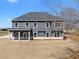 Spacious backyard featuring a covered patio and a well-maintained lawn at 115 River Meadow Ln, Social Circle, GA 30025