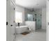Bright bathroom featuring a soaking tub, glass-enclosed shower, and tile flooring at 115 River Meadow Ln, Social Circle, GA 30025