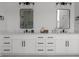 Modern bathroom with double sinks, white cabinetry and grey tile flooring at 115 River Meadow Ln, Social Circle, GA 30025