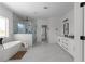 Bright bathroom featuring a soaking tub, glass-enclosed shower, and double vanity at 115 River Meadow Ln, Social Circle, GA 30025