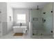 Bright bathroom featuring a soaking tub and glass-enclosed shower with seat at 115 River Meadow Ln, Social Circle, GA 30025