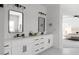 Modern bathroom with double sinks, white cabinetry and grey tile flooring at 115 River Meadow Ln, Social Circle, GA 30025