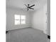 Carpeted bedroom with ceiling fan and window to green outdoor view at 115 River Meadow Ln, Social Circle, GA 30025