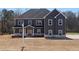 Newly constructed two-story home with gray siding, a gabled roof, and white-framed windows at 115 River Meadow Ln, Social Circle, GA 30025