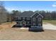 Beautiful two-story home with dark gray siding, a well-manicured lawn, and concrete driveway at 115 River Meadow Ln, Social Circle, GA 30025