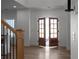Bright foyer featuring wood floors, a staircase with iron railings, and open double doors at 115 River Meadow Ln, Social Circle, GA 30025