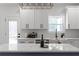 Modern kitchen island with white countertops and a unique geometric light fixture above at 115 River Meadow Ln, Social Circle, GA 30025