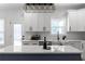 Modern kitchen island with white countertops and a unique geometric light fixture above at 115 River Meadow Ln, Social Circle, GA 30025