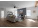 Open-concept living room with fireplace, ceiling fan, and neutral-toned furniture at 115 River Meadow Ln, Social Circle, GA 30025