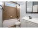 Cozy bathroom featuring a tub with a tile surround, vanity with storage, and a neutral color scheme at 8955 Shalford Ct, Cumming, GA 30041