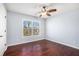 Bright bedroom with hardwood floors, ceiling fan, and large window providing natural light and views at 8955 Shalford Ct, Cumming, GA 30041
