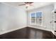 Bedroom featuring sleek dark wood flooring, a ceiling fan, and a window at 8955 Shalford Ct, Cumming, GA 30041