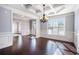 Formal dining room boasts hardwood floors, wainscoting, trey ceiling, and a stylish chandelier at 8955 Shalford Ct, Cumming, GA 30041