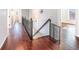 Second story hallway featuring dark wooden floors, ornate banister, and security gate at 8955 Shalford Ct, Cumming, GA 30041