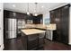 Eat-in kitchen with island, granite countertops, stainless steel appliances, and dark wood cabinets at 8955 Shalford Ct, Cumming, GA 30041