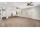 Spacious living room with ceiling fans, large windows and wood look flooring adjacent to carpeted area at 8955 Shalford Ct, Cumming, GA 30041