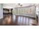 Open-concept living room with hardwood floors, fireplace, and large windows overlooking the backyard at 8955 Shalford Ct, Cumming, GA 30041