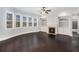 Another view of the bright living room with hardwood floors, fireplace, and built-in shelving at 8955 Shalford Ct, Cumming, GA 30041