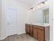 Bathroom featuring double sink vanity, wooden cabinets, and large mirror at 3391 Meadow Grass Dr, Dacula, GA 30019