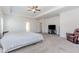 Large primary bedroom with tray ceilings, ceiling fan and seating area at 3391 Meadow Grass Dr, Dacula, GA 30019