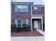 Charming brick townhome with blue shutters, a cozy entrance, and a well-maintained front yard and walkway at 1579 Eastern Sunrise Ln, Decatur, GA 30034