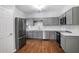 Modern kitchen with gray cabinets, stainless steel appliances, and stylish backsplash at 1579 Eastern Sunrise Ln, Decatur, GA 30034